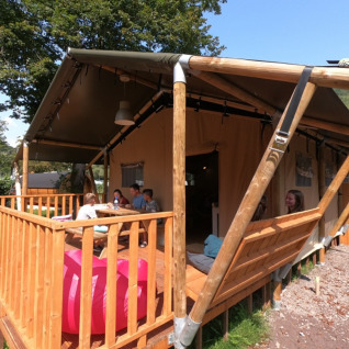 Glamping-Unterkunft bei Camping Alf - Safaritenten Rijnland-Palts mit Gästen auf der Holzterrasse.
