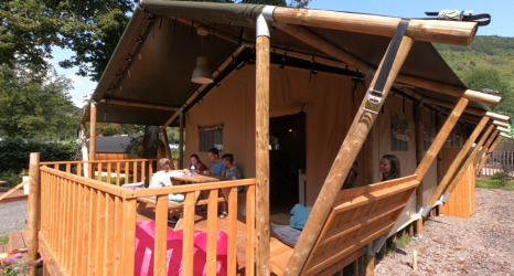 Glamping-Unterkunft bei Camping Alf - Safaritenten Rijnland-Palts mit Gästen auf der Holzterrasse.