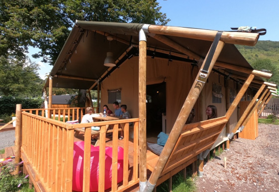 Glamping-Unterkunft bei Camping Alf - Safaritenten Rijnland-Palts mit Gästen auf der Holzterrasse.