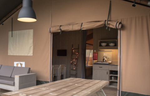 Vista interna del glamping Camping Alf - Safaritenten Rijnland-Palts con cucina e zona soggiorno.