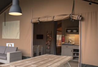Vue intérieure du glamping Camping Alf - Safaritenten Rijnland-Palts avec cuisine et coin salon confortables.