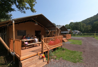 Glamping bij Camping Alf - Safaritenten Rijnland-Palts met gezin op een houten terras en uitzicht.