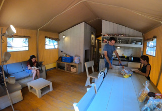 Personen ontspannen en maken eten klaar in een glampingtent bij Camping Alf - Safaritenten Rijnland-Palts.