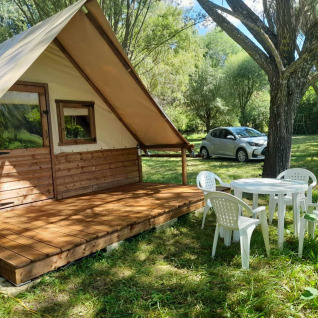 Glamping en Gorges de la Méouge con cabaña, sillas y mesa plásticas, auto y naturaleza de Provenza.
