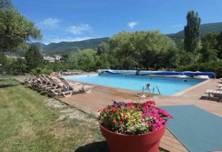 Piscina al aire libre con tumbonas y maceta florida en Gorges de la Meouge - Hut Lodges Provence-Alpes-Côte d'Azur, Francia.