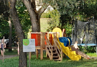 Children playing on a slide and jungle gym in the Gorges de la Meouge Hut Lodges Provence-Alpes-Côte d'Azur campsite.