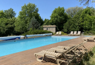 Outdoor swimming pool surrounded by sun loungers and trees at Gorges de la Meouge - Hut Lodges, Provence, France.