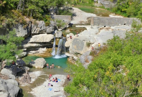 Udsigt over Gorges de la Méouge, med folk der bader ved et vandfald tæt på glamping i Provence.