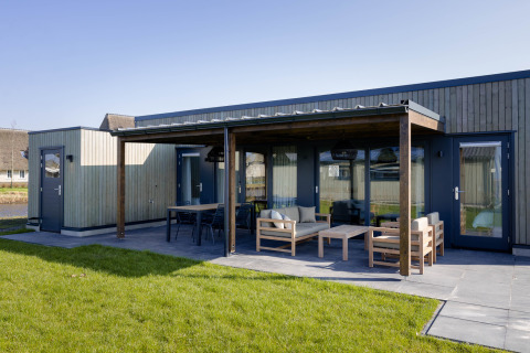Lujosa lodge glamping en Friese Meren Villa’s, Friesland, con terraza cubierta y muebles exteriores modernos.