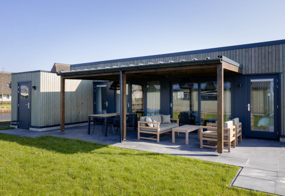 Moderne glamping-lodge ved Friese Meren Villa’s i Friesland med overdækket terrasse og havemøbler.