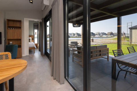 Lodge glamping moderna e di lusso a Friese Meren Villa’s, terrazza arredata e vista lago in Friesland.