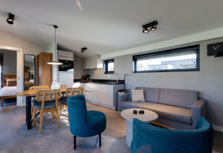 Modern luxury glamping lodge with kitchen, dining area, living room, and view at Friese Meren Villa’s Friesland.