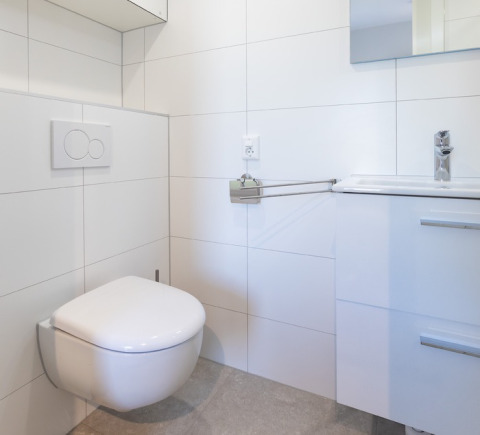 Modern bathroom with wall-mounted toilet and sink, bright decor at Friese Meren Villa’s - Luxe Lodges.