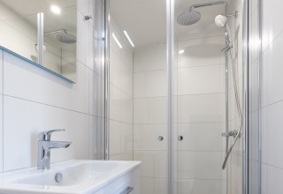 Modernes Badezimmer in einer Luxus-Lodge von Friese Meren Villa’s mit Dusche und Waschbecken in Friesland.