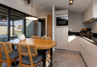 Cuisine et coin repas modernes de glamping aux Friese Meren Villa’s - Luxe lodges Friesland avec vue sur terrasse.