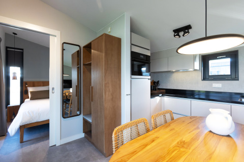 Moderne luxe lodge met slaapkamer, keuken en eettafel bij Friese Meren Villa’s in Friesland, Nederland.