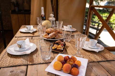 Ontbijttafel met fruit, croissants en koffie bij DivaCamp San Marino - Safaritenten glampinglocatie.