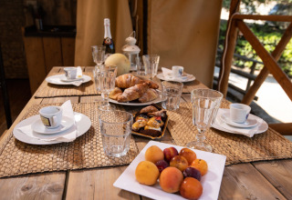 Ontbijttafel met fruit, croissants en koffie bij DivaCamp San Marino - Safaritenten glampinglocatie.