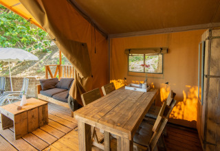 Glamping accommodatie DivaCamp San Marino met rustieke houten tafel en knus terras in safaritent.