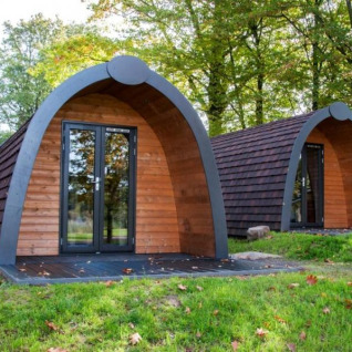 Zwei moderne Glamping-Hütten im Campingpark am Gederner See in Hessen, umgeben von Bäumen und Natur.