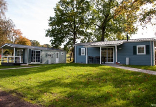 Dos modernas cabañas glamping en Campingpark am Gederner See, Hessen, rodeadas de césped verde y árboles.