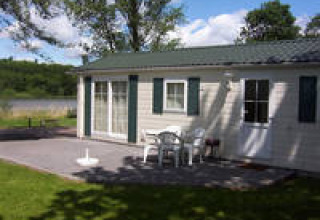 Udendørs terrasse ved Campingpark am Gederner See - Glamping Hessen med borde og stole foran feriebolig.