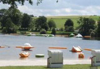 Uitzicht op het meer bij Campingpark am Gederner See met glamping, waterfietsen en groene heuvels in Hessen.