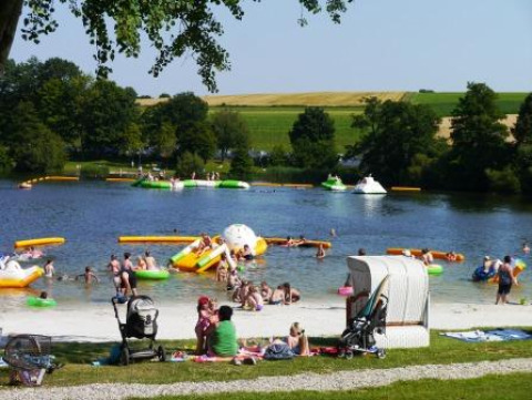 Familier hygger sig ved en sø med glamping og camping i Campingpark am Gederner See - Glamping Hessen.