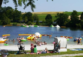 Des familles profitent du lac ensoleillé au Campingpark am Gederner See - Glamping Hessen en Allemagne.