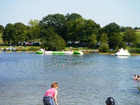 Familien genießen einen Sommertag am See im Campingpark am Gederner See - Glamping Hessen mit Wasserspaß.