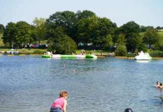 Des familles profitent d'une journée ensoleillée au bord du lac au Campingpark am Gederner See - Glamping Hessen.