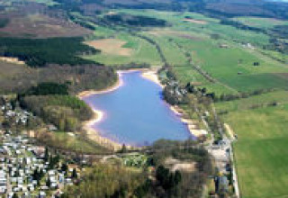 Luftfoto af Campingpark am Gederner See, Glamping Hessen, med sø, grønne områder og campingplads.