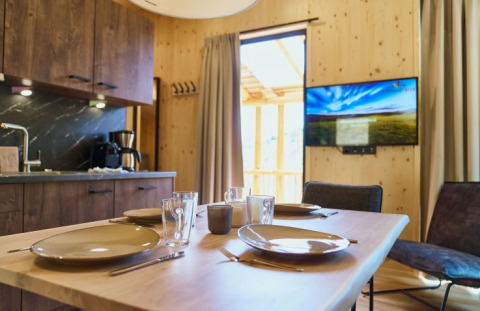 Moderno alloggio glamping UplandParcs Sauerland - Boomhutten Nordrhein-Westfalen con cucina e TV visibili.
