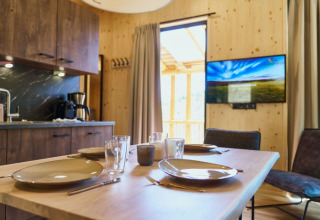 Moderno alloggio glamping UplandParcs Sauerland - Boomhutten Nordrhein-Westfalen con cucina e TV visibili.