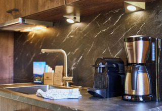 Modern kitchen with coffee maker, capsule machine, and sink at UplandParcs Sauerland - Boomhutten Nordrhein-Westfalen.