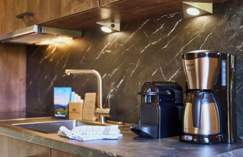 Moderne keuken met koffiezetapparaat, capsulemachine en gootsteen bij UplandParcs Sauerland - Boomhutten Noordrijn-Westfalen.