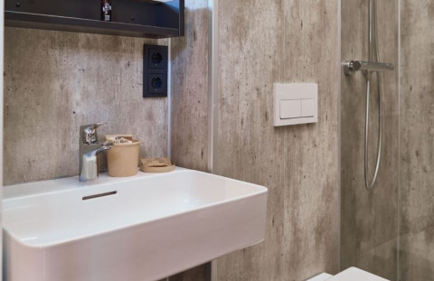 Modernes Badezimmer mit Waschbecken, Wasserhahn und Dusche in der Glamping-Unterkunft UplandParcs Sauerland.