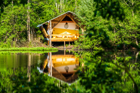 Glamping tent aan een rustige vijver in het groen van Auvergne-Rhône-Alpes, ideaal voor natuurvakantie.