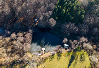 Luchtfoto van Glamping Auvergne bij een bosvijver omringd door bomen en natuur in Auvergne-Rhône-Alpes.