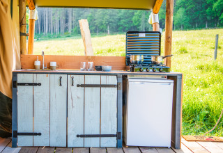 Udendørs køkken med vask, komfur og køleskab på glampingpladsen Glamping Auvergne i Auvergne-Rhone-Alpes.