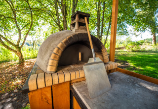 Outdoor stone oven and pizza peel at Glamping Auvergne – Glampingtenten in the Auvergne-Rhone-Alpes region.