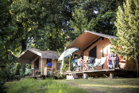 Alojamiento glamping en Huttopia Sarlat - Glamping Dordogne, tiendas cómodas rodeadas de naturaleza verde.