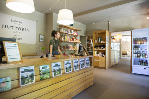 Accueil Huttopia Sarlat - Glamping Dordogne, personnel derrière le comptoir, brochures et produits régionaux.