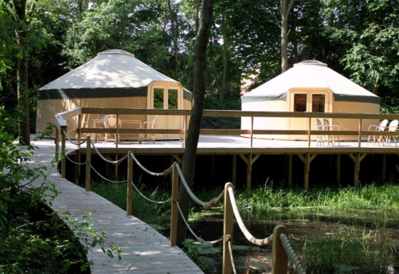 Twee sfeervolle glamping-yurts op een houten terras in het bos bij Uhlenköper-Camp Uelzen, Nedersaksen.