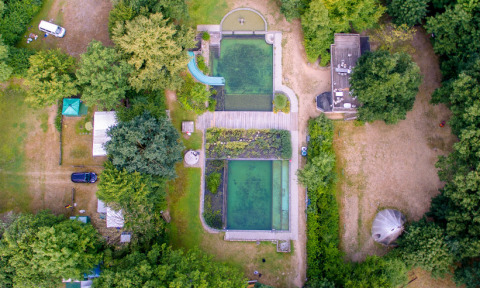 Aerial view of Uhlenköper-Camp Uelzen, Lower Saxony, showing yurts, camping pitches, and natural pools.