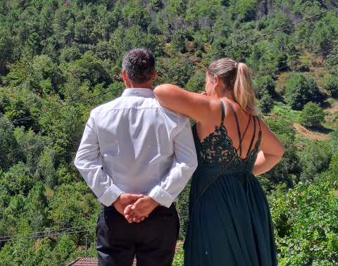 Due persone ammirano il panorama verde dalla glamping Quinta das Corujeiras immersa nella natura.