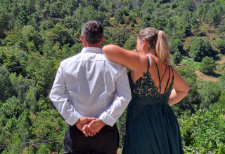 Zwei Personen betrachten gemeinsam die grüne Landschaft bei Quinta das Corujeiras Glamping-Unterkunft.