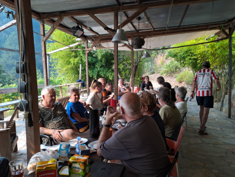 Grupo de personas compartiendo una comida en Quinta das Corujeiras, un alojamiento glamping en la naturaleza.