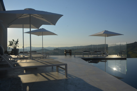 Luxuriöse Sonnenliegen und Sonnenschirme am Infinity-Pool mit Panoramablick bei Brezza di sera Glamping.