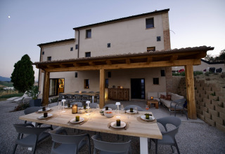 Außenterrasse mit gedecktem Tisch bei Brezza di sera agriturismo - Glampingtenten Le Marche in Italien.